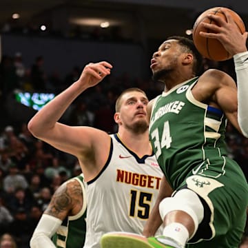 Feb 27, 2025; Milwaukee, Wisconsin, USA; Milwaukee Bucks forward Giannis Antetokounmpo (34) grabs a rebound against Denver Nuggets center Nikola Jokic (15) in the third quarter at Fiserv Forum. Mandatory Credit: Benny Sieu-Imagn Images
