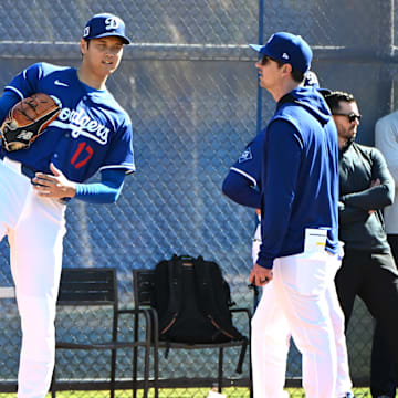 Los Angeles Dodgers designated hitter Shohei Ohtani (17) works with Los Angeles Dodgers assistant pitching coach Connor McGuiness (87) during a spring training bullpen session at Camelback Ranch in 2025.