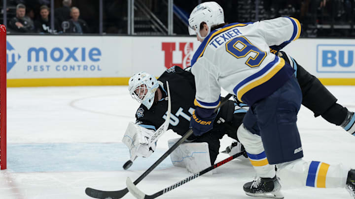 Feb 2, 2025; Salt Lake City, Utah, USA; Utah Hockey Club goaltender Connor Ingram (39) dives for the puck off of a St. Louis Blues center Alexandre Texier (9) shot during the first period at Delta Center. Mandatory Credit: Chris Nicoll-Imagn Images