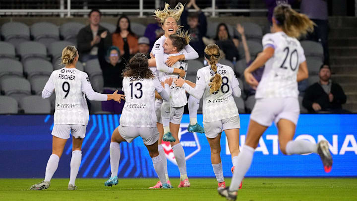 Taylor Flint (26) is swarmed by her Racing Louisville teammates after keeping their playoff dreams alive against Portland Thorns FC |  Credit: Kareem Elgazzar-Imagn Images