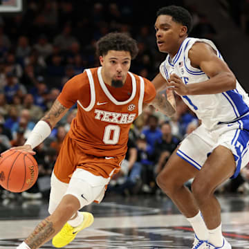 Texas Longhorns guard Jordan Pope (0) drives the ball around Duke Blue Devils guard Caleb Foster (1).