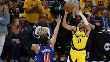 May 27, 2025; Indianapolis, Indiana, USA; Indiana Pacers guard Tyrese Haliburton (0) shoots a three-point basket over New York Knicks guard Jalen Brunson (11) during the fourth quarter of game four of the Eastern Conference Finals for the 2025 NBA Playoffs at Gainbridge Fieldhouse. Mandatory Credit: Trevor Ruszkowski-Imagn Images