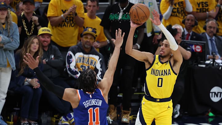 May 27, 2025; Indianapolis, Indiana, USA; Indiana Pacers guard Tyrese Haliburton (0) shoots a three-point basket over New York Knicks guard Jalen Brunson (11) during the fourth quarter of game four of the Eastern Conference Finals for the 2025 NBA Playoffs at Gainbridge Fieldhouse. Mandatory Credit: Trevor Ruszkowski-Imagn Images