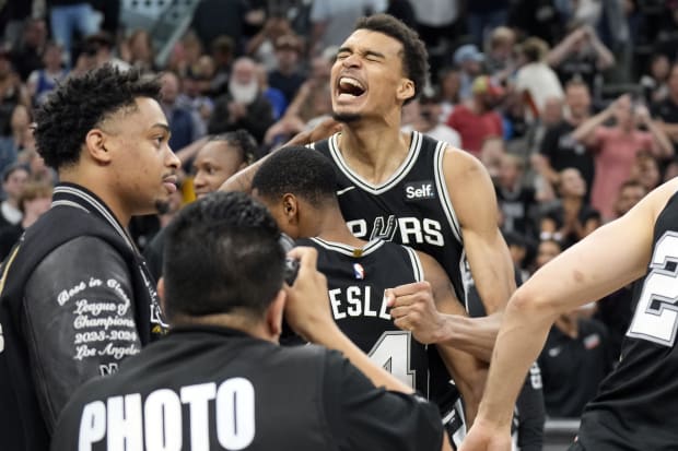 San Antonio Spurs forward Victor Wembanyama and teammates react after a victory over the Denver Nuggets at Frost Bank Center.