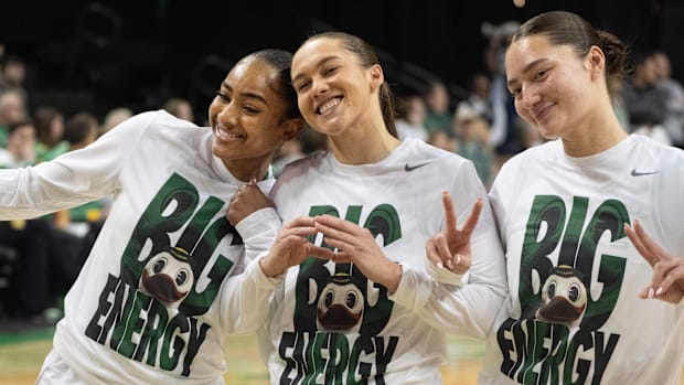 Oregon’s Deja Kelly, left, Peyton Scott and Nani Falatea join the tam on the court before their game against Rutgers at Matth