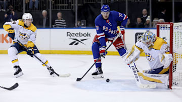 Mar 2, 2025; New York, New York, USA; New York Rangers center Matt Rempe (73) plays the puck against Nashville Predators goaltender Justus Annunen (29) and defenseman Spencer Stastney (24) during the second period at Madison Square Garden. Mandatory Credit: Brad Penner-Imagn Images