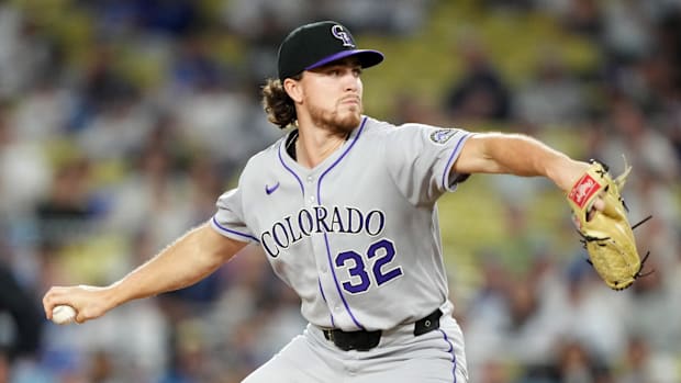 Colorado Rockies pitcher Chase Dollander throws in a gray uniform and black hat