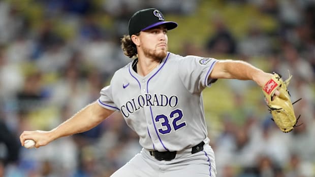 Colorado Rockies pitcher Chase Dollander throws in gray uniform and black hat