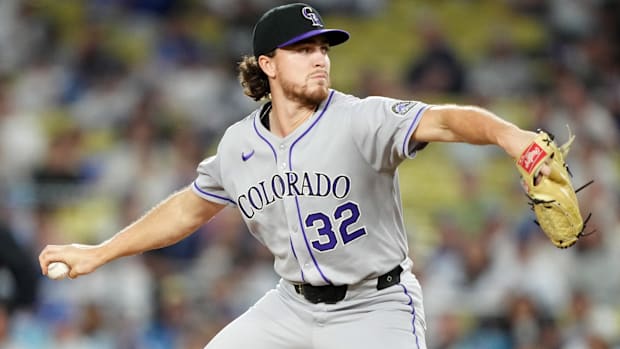 Chase Dollander pitching for the Colorado Rockies in all grey uniform. 