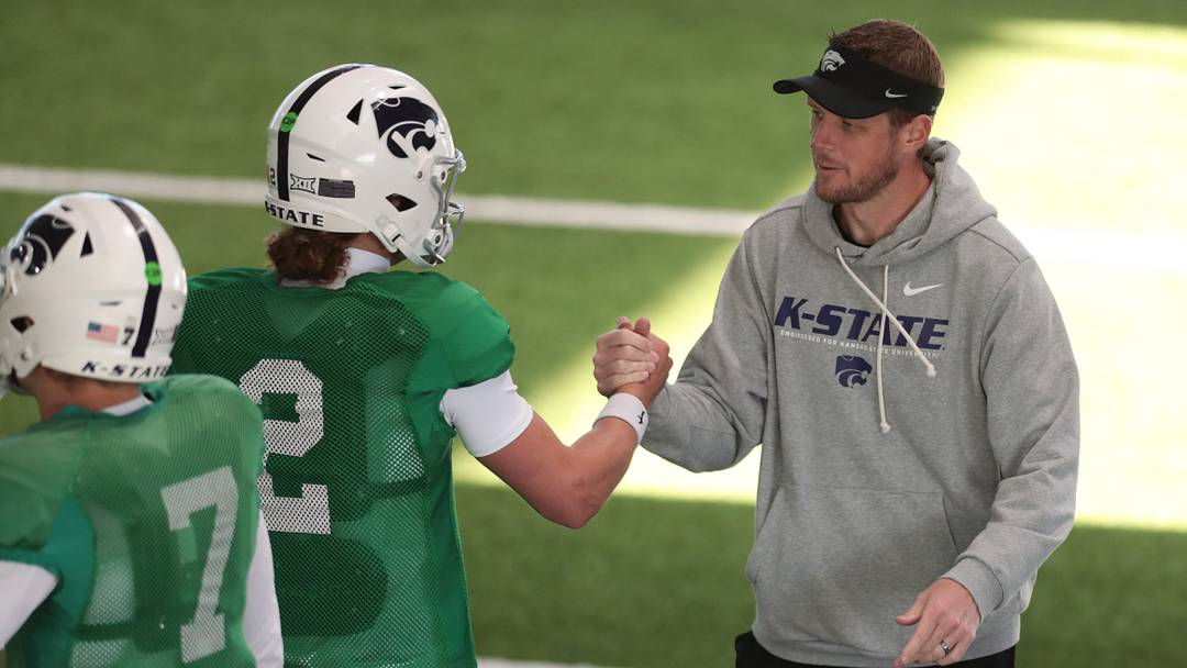 Kansas State head coach Collin Klein slaps hands with senior quarterback Avery Johnson (2) during practice on Tuesday, April 21, 2026. Kansas State head coach Collin Klein slaps hands with senior quarterback Avery Johnson (2) during practice on Tuesday, April 21, 2026.