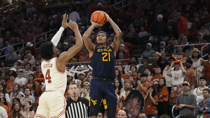 Feb 10, 2024; Austin, Texas, USA; West Virginia Mountaineers guard RaeQuan Battle (21) shoots over Texas Longhorns guard Tyrese Hunter (4) during the second half at Moody Center. 