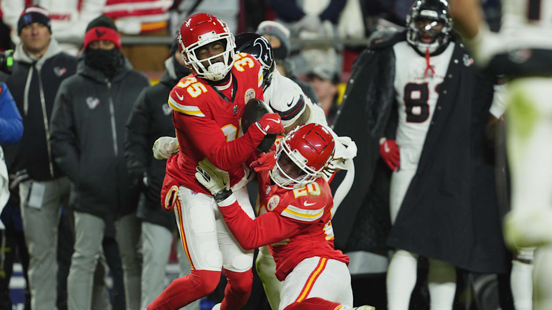Jan 18, 2025; Kansas City, Missouri, USA; Kansas City Chiefs cornerback Jaylen Watson (35) and safety Justin Reid (20) break up a pass intended for Houston Texans wide receiver Nico Collins (12) during the fourth quarter of a 2025 AFC divisional round game at GEHA Field at Arrowhead Stadium. Mandatory Credit: Jay Biggerstaff-Imagn Images