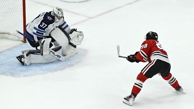 Hockey player in red uniform shoots the puck