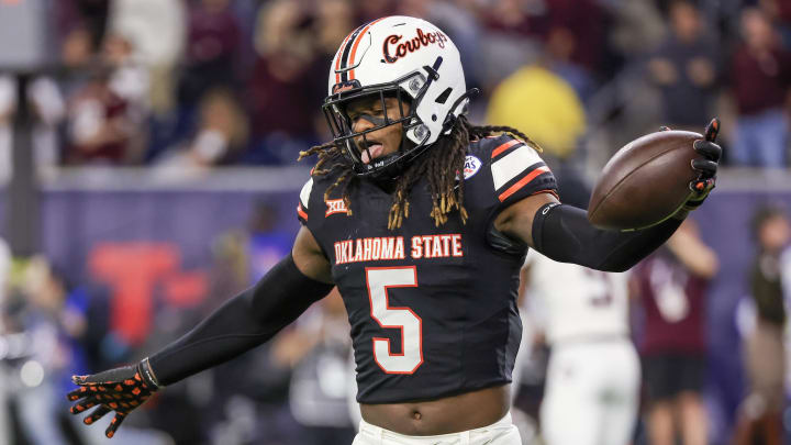 Dec 27, 2023; Houston, TX, USA; Oklahoma State Cowboys safety Kendal Daniels (5)  celebrates his interception against the Texas A&M Aggies in the second half at NRG Stadium. Mandatory Credit: Thomas Shea-USA TODAY Sports