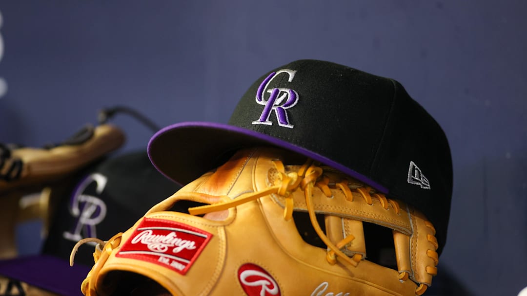 Jun 15, 2023; Atlanta, Georgia, USA; A detailed view of a Colorado Rockies hat and glove on the bench against the Atlanta Braves in the ninth inning at Truist Park. Mandatory Credit: Brett Davis-Imagn Images