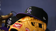 Jun 15, 2023; Atlanta, Georgia, USA; A detailed view of a Colorado Rockies hat and glove on the bench against the Atlanta Braves in the ninth inning at Truist Park. 