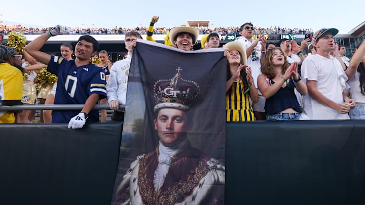 Oct 11, 2025; Atlanta, Georgia, USA; Georgia Tech Yellow Jackets fans celebrate with a flag of quarterback Haynes King (10) after a victory over the Virginia Tech Hokies in the fourth quarter at Bobby Dodd Stadium at Hyundai Field. Mandatory Credit: Brett Davis-Imagn Images
Oct 11, 2025; Atlanta, Georgia, USA; Georgia Tech Yellow Jackets fans celebrate with a flag of quarterback Haynes King (10) after a victory over the Virginia Tech Hokies in the fourth quarter at Bobby Dodd Stadium at Hyundai Field. Mandatory Credit: Brett Davis-Imagn Images