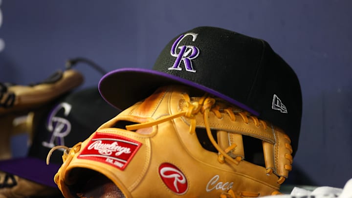 Jun 15, 2023; Atlanta, Georgia, USA; A detailed view of a Colorado Rockies hat and glove on the bench against the Atlanta Braves in the ninth inning at Truist Park. 