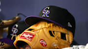 Jun 15, 2023; Atlanta, Georgia, USA; A detailed view of a Colorado Rockies hat and glove on the bench against the Atlanta Braves in the ninth inning at Truist Park. 