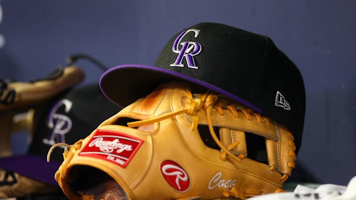 Jun 15, 2023; Atlanta, Georgia, USA; A detailed view of a Colorado Rockies hat and glove on the bench against the Atlanta Braves in the ninth inning at Truist Park. 