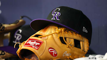 Jun 15, 2023; Atlanta, Georgia, USA; A detailed view of a Colorado Rockies hat and glove on the bench against the Atlanta Braves in the ninth inning at Truist Park. Mandatory Credit: Brett Davis-Imagn Images
