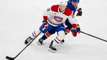 Apr 11, 2024; Elmont, New York, USA; Montreal Canadiens center Christian Dvorak (28) skates with the puck chased by New York Islanders center Kyle MacLean (32) during the second period at UBS Arena. Mandatory Credit: Dennis Schneidler-USA TODAY Sports