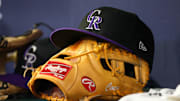 Jun 15, 2023; Atlanta, Georgia, USA; A detailed view of a Colorado Rockies hat and glove on the bench against the Atlanta Braves in the ninth inning at Truist Park.