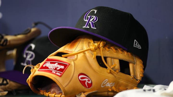 Jun 15, 2023; Atlanta, Georgia, USA; A detailed view of a Colorado Rockies hat and glove on the bench against the Atlanta Braves in the ninth inning at Truist Park.