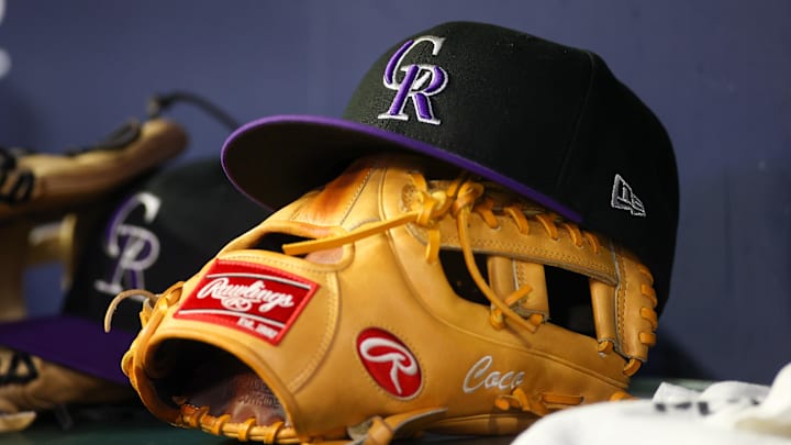 Jun 15, 2023; Atlanta, Georgia, USA; A detailed view of a Colorado Rockies hat and glove on the bench against the Atlanta Braves in the ninth inning at Truist Park. 