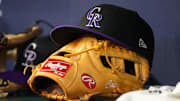 Jun 15, 2023; Atlanta, Georgia, USA; A detailed view of a Colorado Rockies hat and glove on the bench against the Atlanta Braves in the ninth inning at Truist Park.