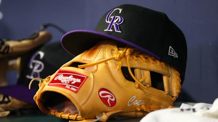 Jun 15, 2023; Atlanta, Georgia, USA; A detailed view of a Colorado Rockies hat and glove on the bench against the Atlanta Braves in the ninth inning at Truist Park. 