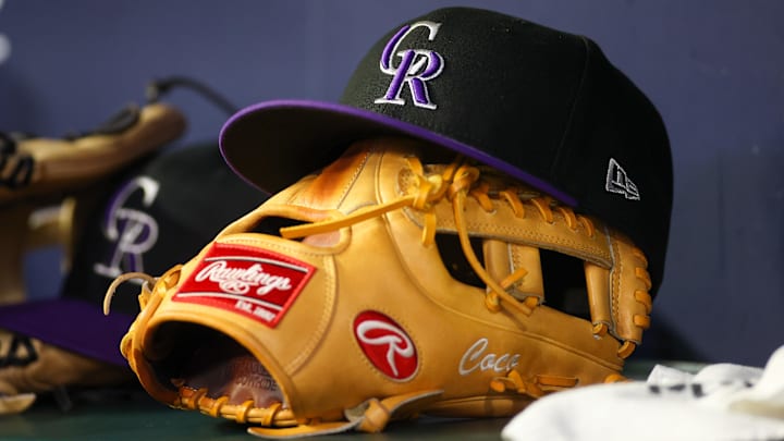 A detailed view of a Colorado Rockies hat and glove on the bench against the Atlanta Braves in the ninth inning at Truist Park. A detailed view of a Colorado Rockies hat and glove on the bench against the Atlanta Braves in the ninth inning at Truist Park.