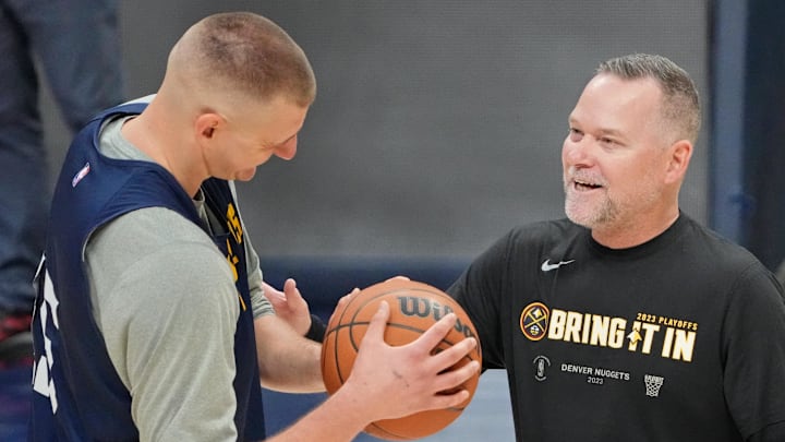 Denver Nuggets star Nikola Jokic talks to coach Michael Malone during warm-ups.