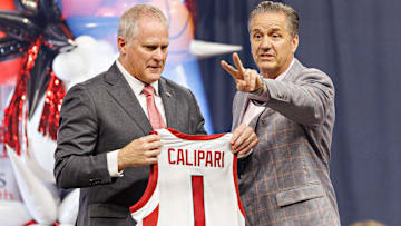 University of Arkansas Athletic Director holds up a No. 1 Razorback basketball jersey during the introductory press conference for John Calipari last spring. 