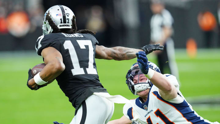 Jan 7, 2024; Paradise, Nevada, USA; Las Vegas Raiders wide receiver Davante Adams (17) stiff-arms Denver Broncos linebacker Drew Sanders (41) during the second quarter at Allegiant Stadium. Mandatory Credit: Stephen R. Sylvanie-USA TODAY Sports