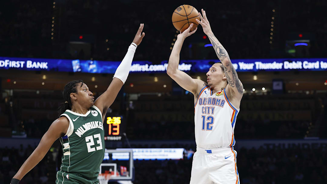 Apr 12, 2024; Oklahoma City, Oklahoma, USA; Oklahoma City Thunder forward Lindy Waters III (12) shoots a three-point basket as Milwaukee Bucks guard TyTy Washington Jr. (23) defends during the fourth quarter at Paycom Center. Mandatory Credit: Alonzo Adams-Imagn Images
