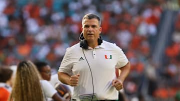 Sep 7, 2024; Miami Gardens, Florida, USA; Miami Hurricanes head coach Mario Cristobal runs on the sideline against the Florida A&M Rattlers during the first quarter at Hard Rock Stadium. Mandatory Credit: Sam Navarro-Imagn Images