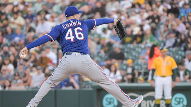 Texas Rangers pitcher Patrick Corbin throwing a ball against the Athletics in a blue uniform. 