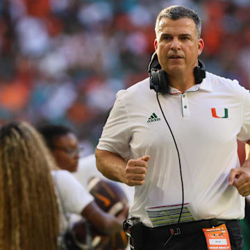 Sep 7, 2024; Miami Gardens, Florida, USA; Miami Hurricanes head coach Mario Cristobal runs on the sideline against the Florida A&M Rattlers during the first quarter at Hard Rock Stadium. Mandatory Credit: Sam Navarro-Imagn Images