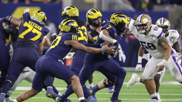 Jan 8, 2024; Houston, TX, USA; Michigan Wolverines quarterback Alex Orji (10) pulls the ball out of the arms of running back Donovan Edwards (7) against the Washington Huskies  in the 2024 College Football Playoff national championship game at NRG Stadium. Mandatory Credit: Thomas Shea-USA TODAY Sports