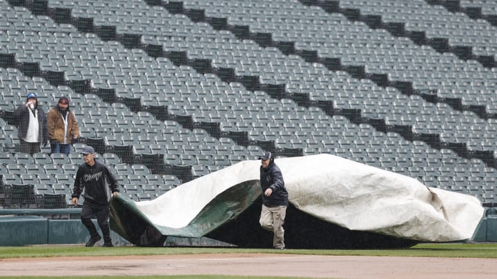 Chicago White Sox grounds crew covers the field with a tarp during a rain delay