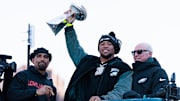 Philadelphia Eagles running back Saquon Barkley lifts the Lombardi Trophy during the Super Bowl LIX championship parade.
