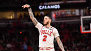 Feb 28, 2025; Chicago, Illinois, USA; Chicago Bulls forward Lonzo Ball (2) hits a three point shot against Toronto Raptors guard Jamal Shead (23) during overtime at the United Center. Mandatory Credit: Patrick Gorski-Imagn Images