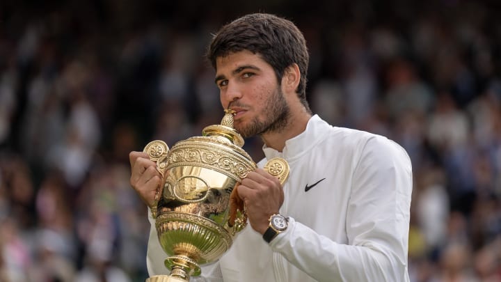 Jul 16, 2023; London, United Kingdom; Carlos Alcaraz (ESP) kisses with the trophy after winning  the men   s singles final against Novak Djokovic (SRB) on day 14 at  the All England Lawn Tennis and Croquet Club. 