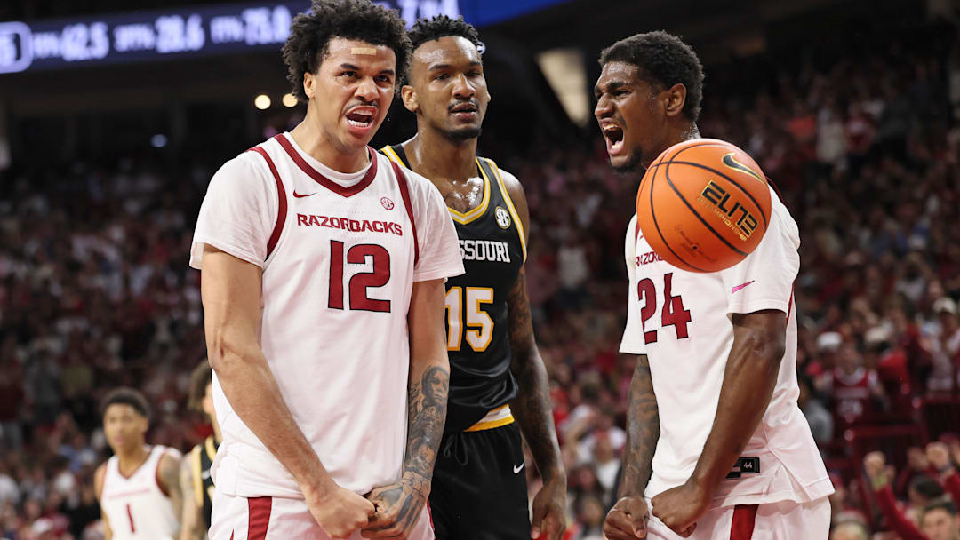 Feb 21, 2026; Fayetteville, Arkansas, USA; Arkansas Razorbacks forward Malique Ewin (12) and wing Billy Richmond III (24) react after a score as Missouri Tigers center Shawn Phillips Jr (15) looks on during the first half at Bud Walton Arena. Mandatory Credit: Nelson Chenault-Imagn Images