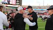Oct 25, 2025; Lubbock, Texas, USA;  Oklahoma State Cowboys interim head coach Doug Meacham and Texas Tech Red Raiders head coach Joey McGuire meet at mid-field after the game at Jones AT&T Stadium. Mandatory Credit: Michael C. Johnson-Imagn Images