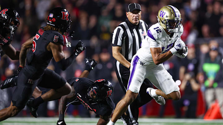 Sep 27, 2024; Piscataway, New Jersey, USA; Washington Huskies wide receiver Denzel Boston (12) breaks a tackle by Rutgers Scarlet Knights linebacker Moses Walker (2) for a touchdown during the second half at SHI Stadium. Mandatory Credit: Vincent Carchietta-Imagn Images