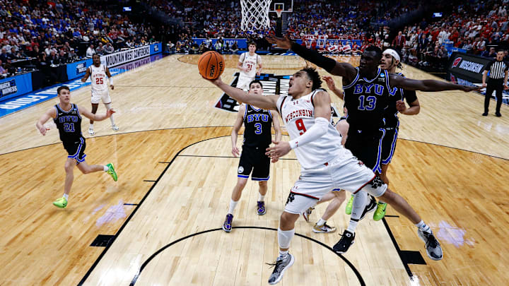 Mar 22, 2025; Denver, CO, USA; Wisconsin Badgers guard John Tonje (9) drives to the net against Brigham Young Cougars center Keba Keita (13) as guard Egor Demin (3) and guard Trey Stewart (1) defend in the first half at Ball Arena. Mandatory Credit: Isaiah J. Downing-Imagn Images