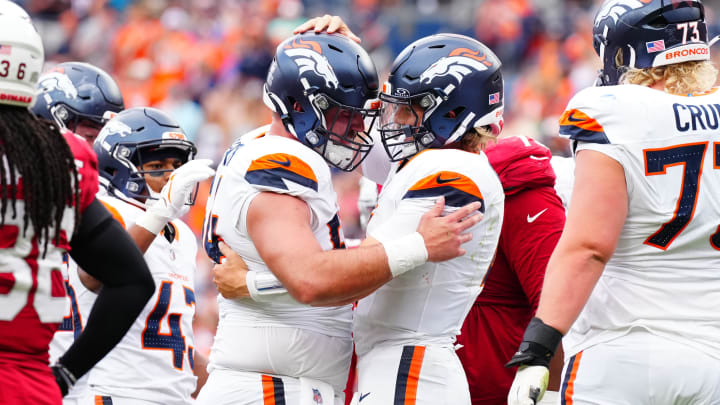 Aug 25, 2024; Denver, Colorado, USA; Denver Broncos quarterback Zach Wilson (4) celebrates his rushing touchdown with center Alex Forsyth (54) in the second half at Empower Field at Mile High. 