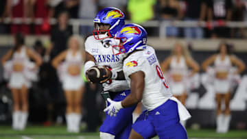 Oct 11, 2025; Lubbock, Texas, USA;  Kansas Jayhawks quarterback Jalon Daniels (6) in the second half gives the ball to running back Daniel Hishaw Jr. (9) against the Texas Tech Red Raiders at Jones AT&T Stadium. Mandatory Credit: Michael C. Johnson-Imagn Images